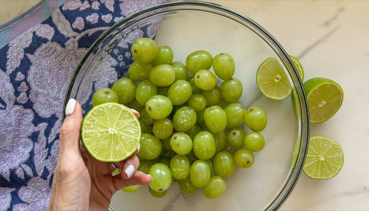 grapes being tossed in fresh squeezed lime juice in a large bowl